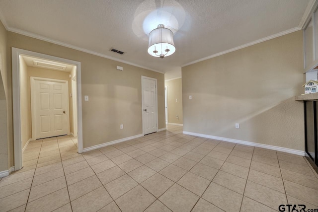 empty room featuring light tile patterned flooring, ornamental molding, and a textured ceiling