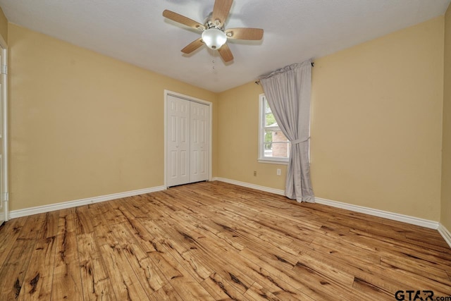 unfurnished bedroom featuring light wood-type flooring, a closet, and ceiling fan