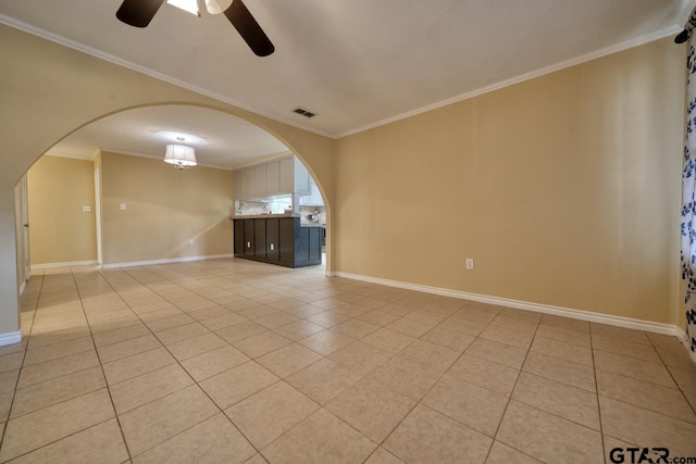 spare room with crown molding, ceiling fan, and light tile patterned floors