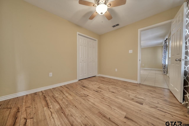 unfurnished bedroom featuring a closet, light hardwood / wood-style flooring, and ceiling fan