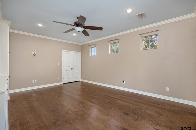 empty room featuring crown molding, dark wood-type flooring, and ceiling fan