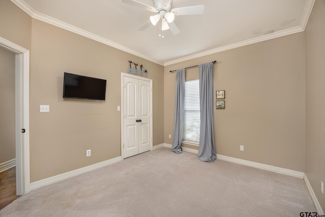 unfurnished bedroom featuring ceiling fan, ornamental molding, a closet, and light carpet