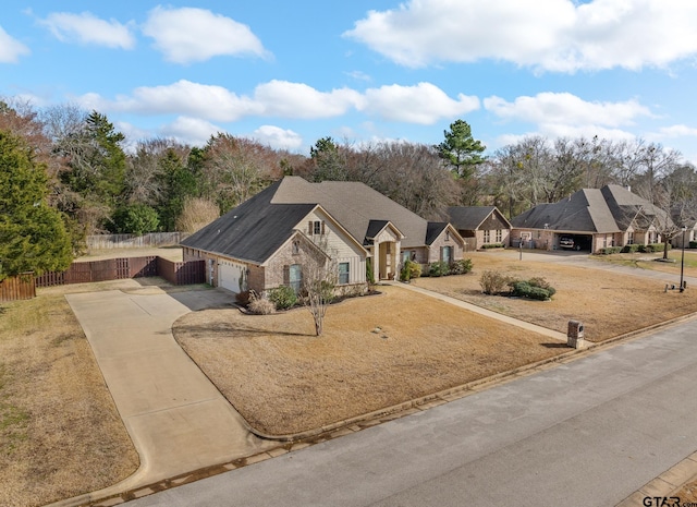 view of front of house with a residential view, concrete driveway, and fence