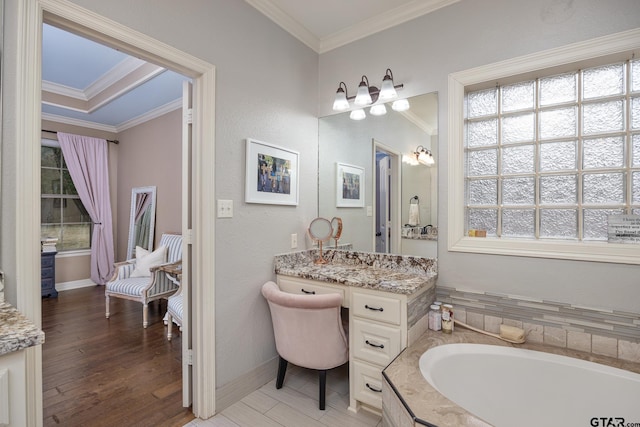 bathroom featuring crown molding, vanity, a bathing tub, and hardwood / wood-style flooring