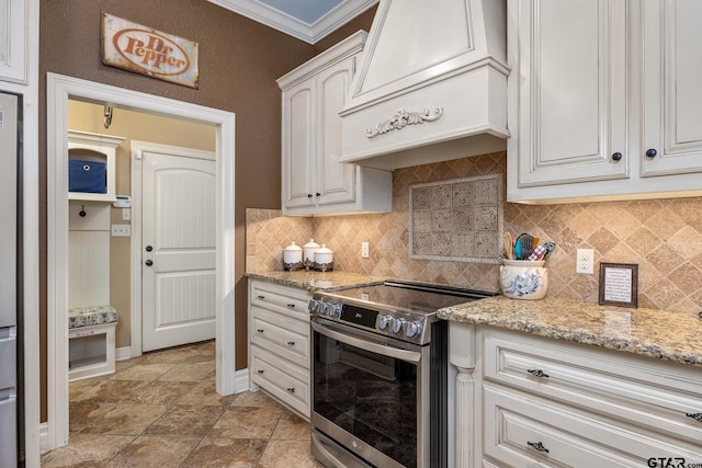 kitchen with white cabinetry, stainless steel range with electric cooktop, backsplash, custom exhaust hood, and light stone countertops