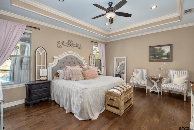 bedroom with crown molding, a tray ceiling, dark hardwood / wood-style floors, and ceiling fan