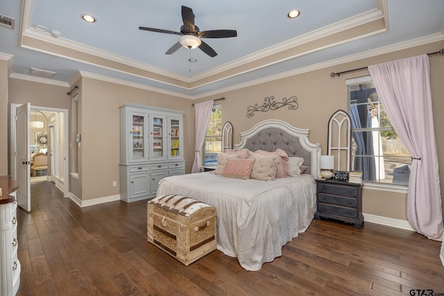 bedroom with dark wood-type flooring, ceiling fan, a tray ceiling, and crown molding