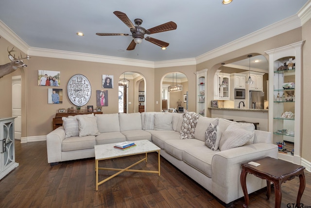 living room with dark wood-type flooring, ceiling fan, ornamental molding, and sink