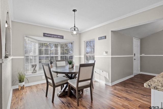 dining space featuring dark wood-type flooring and ornamental molding