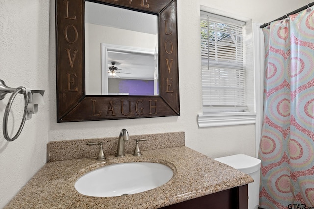 bathroom featuring vanity, ceiling fan, toilet, and curtained shower