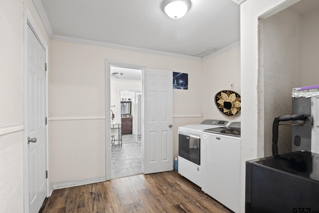 laundry room with washing machine and dryer, crown molding, and dark wood-type flooring