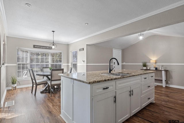 kitchen with a kitchen island with sink, sink, pendant lighting, white cabinets, and lofted ceiling