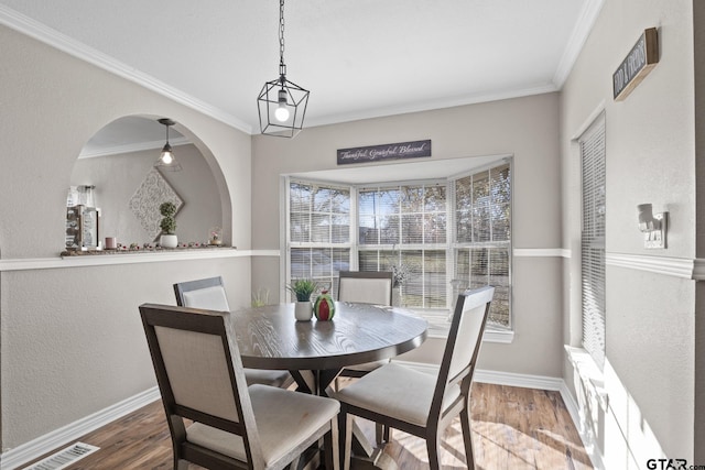 dining room with hardwood / wood-style floors and crown molding