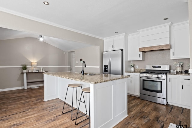 kitchen with lofted ceiling, premium range hood, a kitchen island with sink, appliances with stainless steel finishes, and white cabinetry