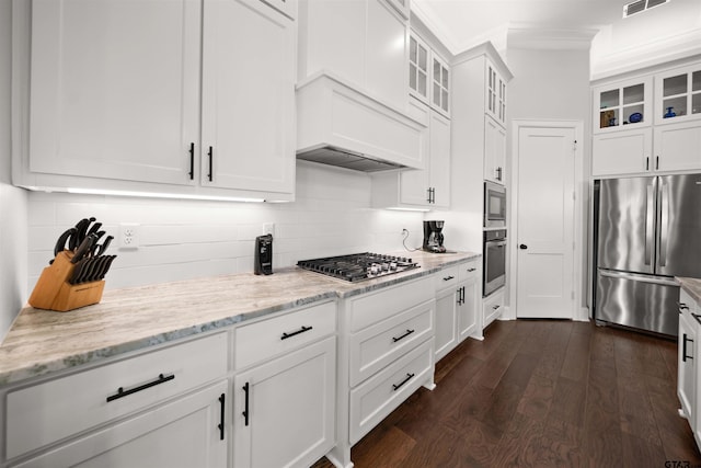 kitchen with dark hardwood / wood-style floors, backsplash, white cabinets, light stone counters, and stainless steel appliances