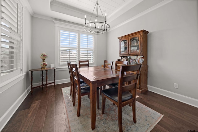 dining room with a raised ceiling, crown molding, dark wood-type flooring, and an inviting chandelier