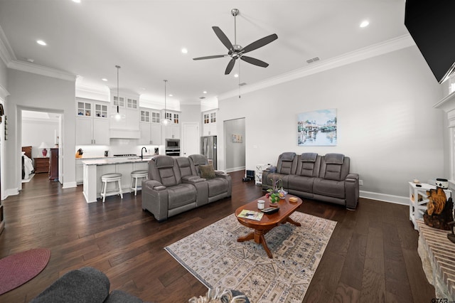 living room featuring dark hardwood / wood-style flooring, a fireplace, ornamental molding, and ceiling fan