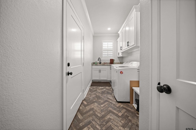 laundry area with cabinets, independent washer and dryer, ornamental molding, and sink