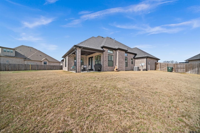 rear view of property featuring a patio, a yard, and central air condition unit