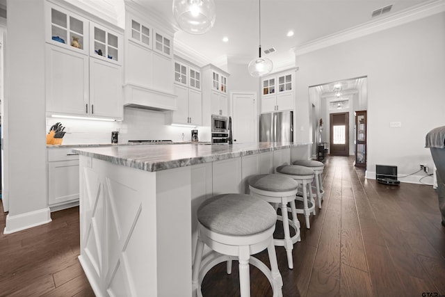 kitchen with hanging light fixtures, a center island, white cabinets, and appliances with stainless steel finishes