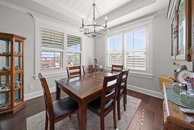 dining room featuring dark wood-type flooring, a tray ceiling, a chandelier, and crown molding