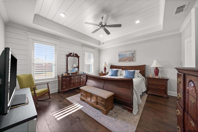 bedroom featuring dark hardwood / wood-style floors, ceiling fan, a tray ceiling, and crown molding