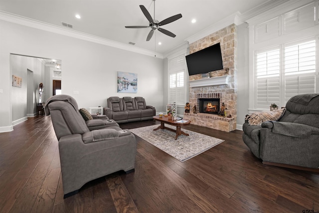 living room with dark hardwood / wood-style flooring, crown molding, a stone fireplace, and ceiling fan