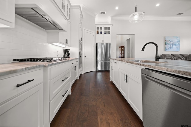 kitchen featuring pendant lighting, sink, premium range hood, appliances with stainless steel finishes, and white cabinets