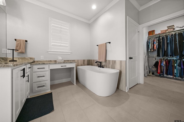 bathroom featuring tile walls, vanity, a bath, ornamental molding, and tile patterned floors