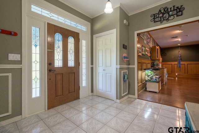 1017 Hilltop Dr, Palestine, TX 75801 - entryway with a decorative wall, ornamental molding, light tile patterned floors, and a wainscoted wall