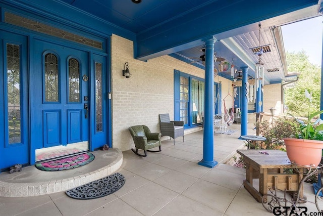 1017 Hilltop Dr, Palestine, TX 75801 - property entrance featuring a ceiling fan, a porch, and brick siding