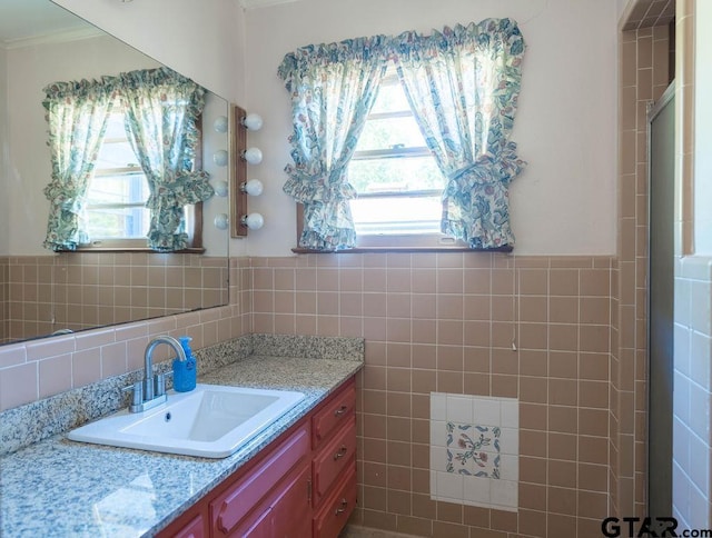1017 Hilltop Dr, Palestine, TX 75801 - full bath with a healthy amount of sunlight, tile walls, a shower with door, and vanity