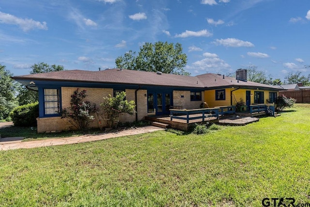 1017 Hilltop Dr, Palestine, TX 75801 - back of house with a yard, brick siding, a wooden deck, and a chimney