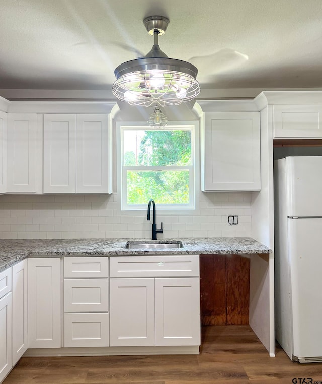 kitchen with white cabinetry, dark wood-type flooring, sink, and white refrigerator