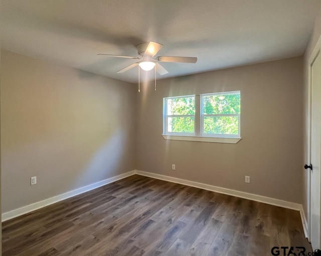 empty room featuring dark wood-type flooring and ceiling fan