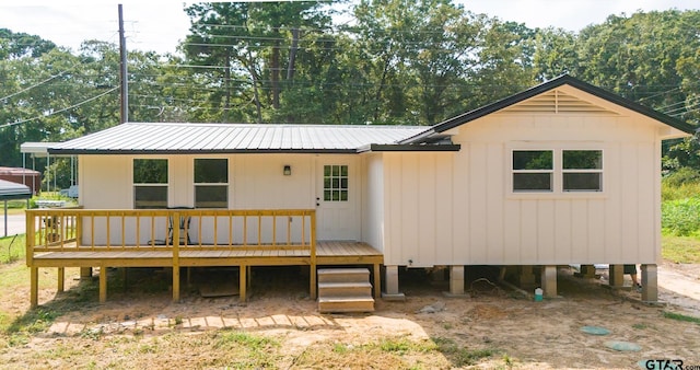 rear view of house featuring a wooden deck