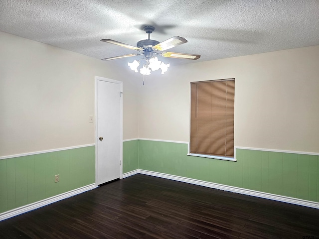 unfurnished room with a textured ceiling, ceiling fan, and dark wood-type flooring