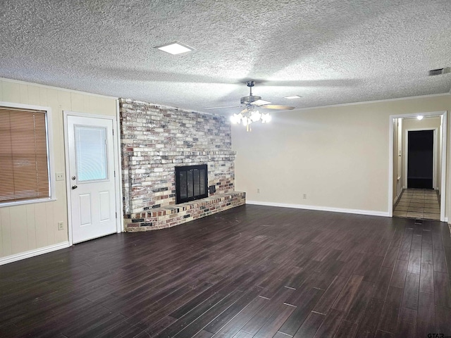 unfurnished living room with ceiling fan, a brick fireplace, dark hardwood / wood-style flooring, crown molding, and a textured ceiling