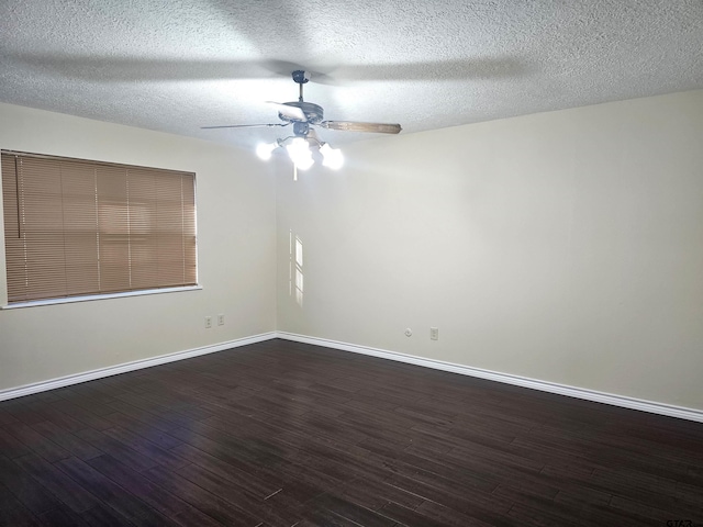 empty room with ceiling fan, dark wood-type flooring, and a textured ceiling