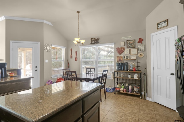 kitchen with light stone countertops, a notable chandelier, lofted ceiling, decorative light fixtures, and light tile patterned flooring