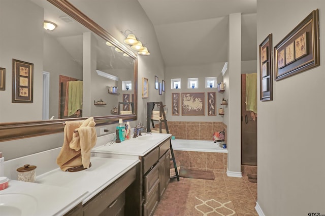 bathroom featuring tile patterned floors, vanity, a relaxing tiled tub, and lofted ceiling