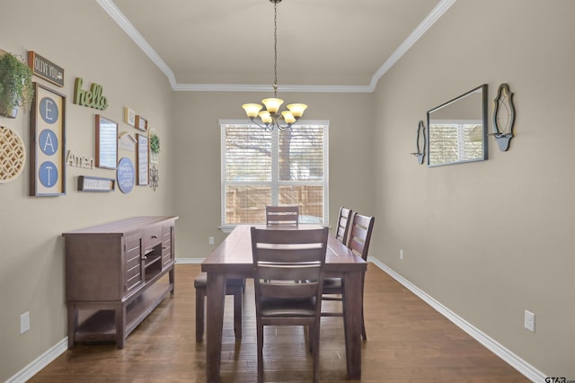 dining room featuring dark hardwood / wood-style floors, crown molding, and a notable chandelier