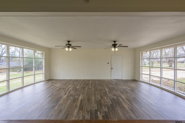 unfurnished living room with ceiling fan and dark hardwood / wood-style flooring