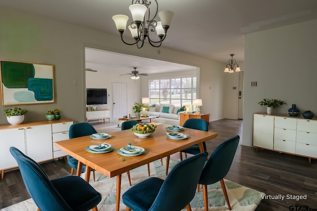 dining area with ceiling fan with notable chandelier and dark hardwood / wood-style flooring