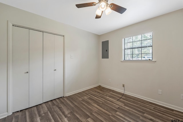 unfurnished bedroom with dark wood-type flooring, ceiling fan, a closet, and electric panel