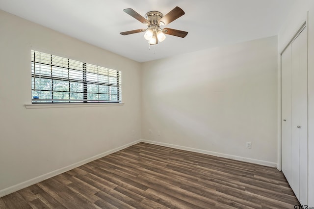 spare room with dark wood-type flooring and ceiling fan