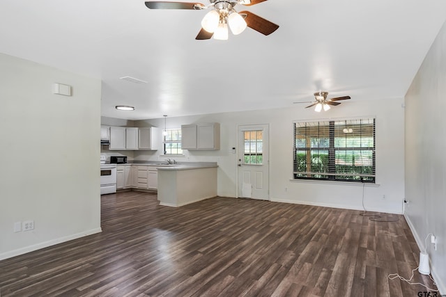 kitchen with white electric stove, dark hardwood / wood-style flooring, sink, kitchen peninsula, and ceiling fan