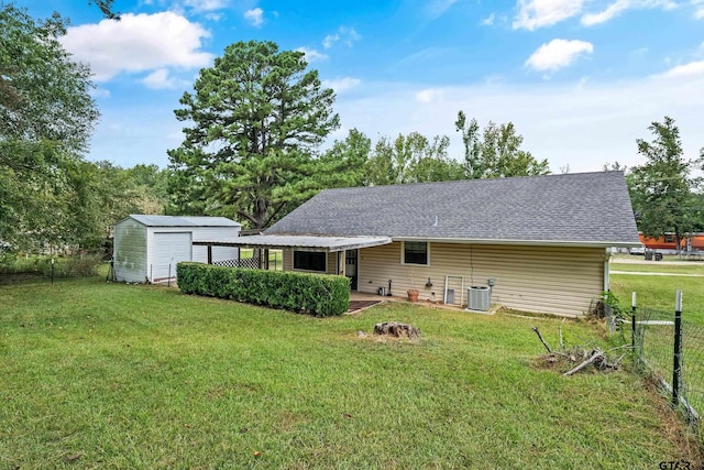 rear view of property with cooling unit, a lawn, a fire pit, and a storage shed