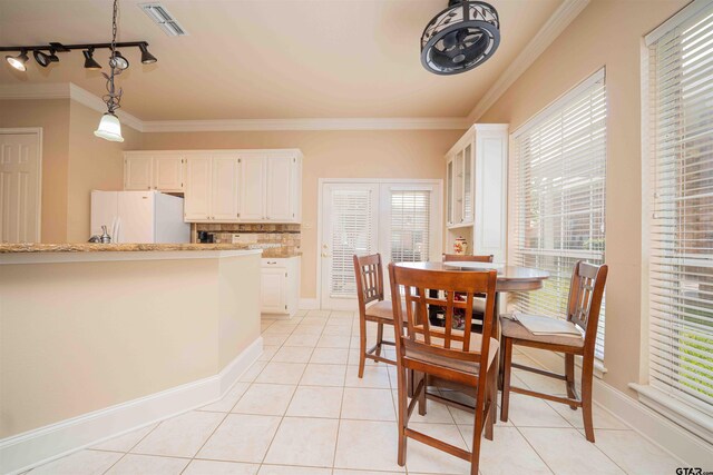 2215 Homestead Ln, Tyler, TX 75701 - dining space with crown molding, baseboards, light tile patterned floors, and visible vents