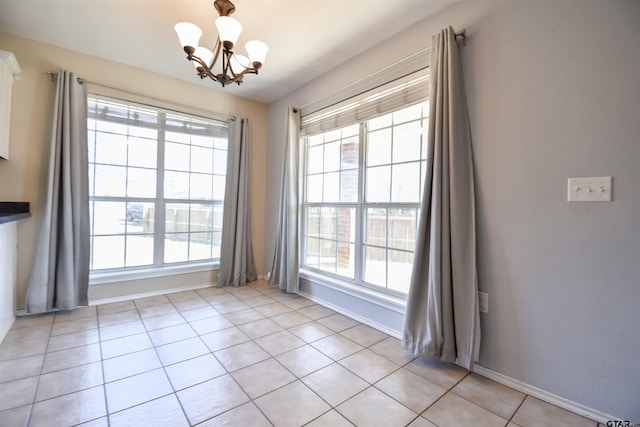 interior space featuring an inviting chandelier, light tile patterned floors, and a healthy amount of sunlight